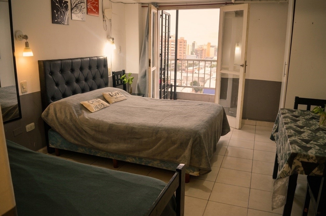 Dormitorio con cama doble y balcón