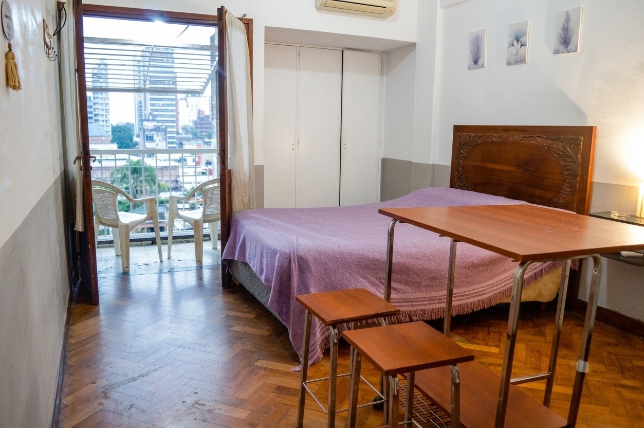 Ambiente con balcón y cama doble